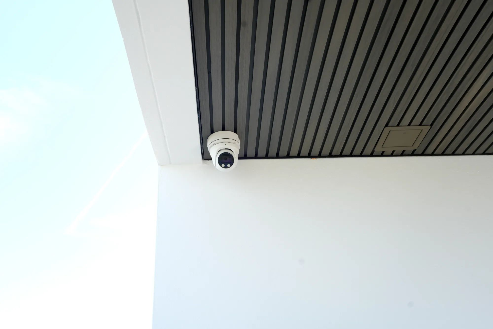 Exterior camera installed under a soffit near a building entrance