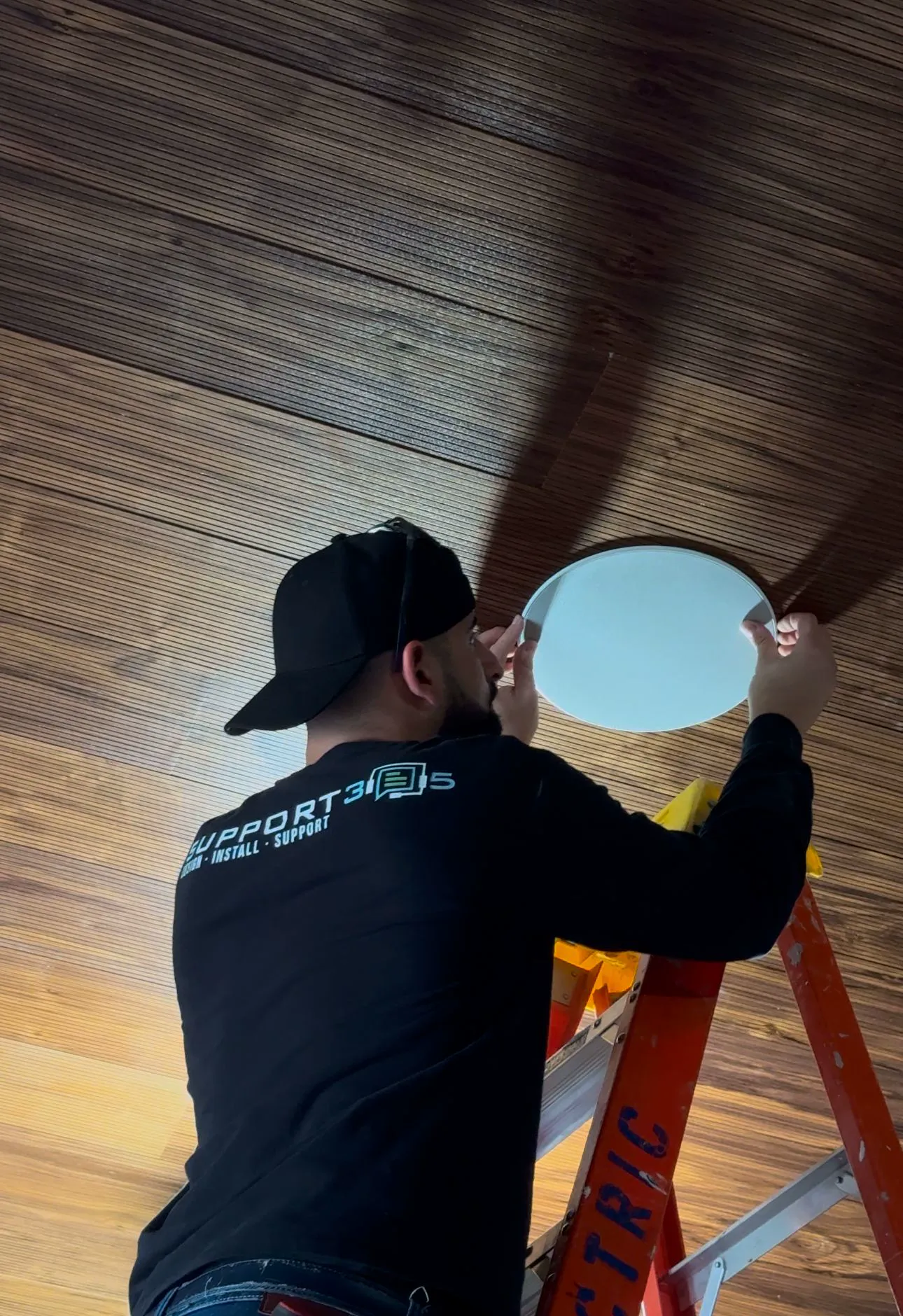 DIST technician cutting in an in-ceiling speaker