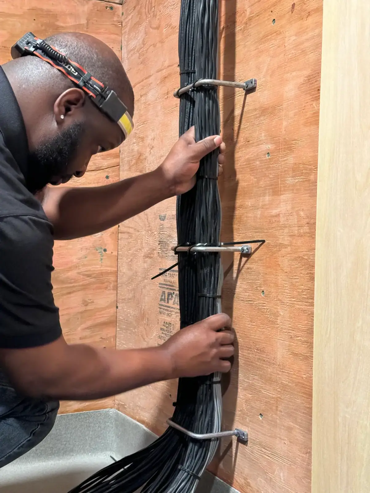 Technician dressing a bundle of low-voltage cable along J-hooks