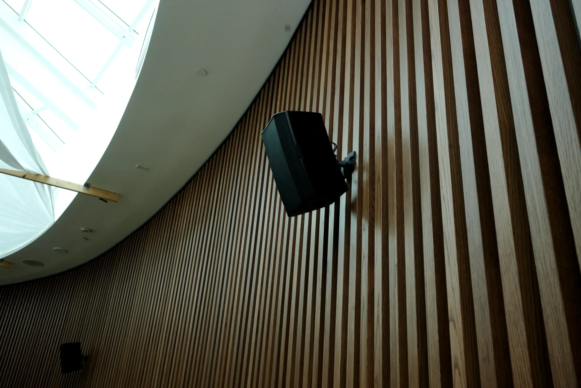 Surface-mount loudspeaker installed on a slatted wood wall