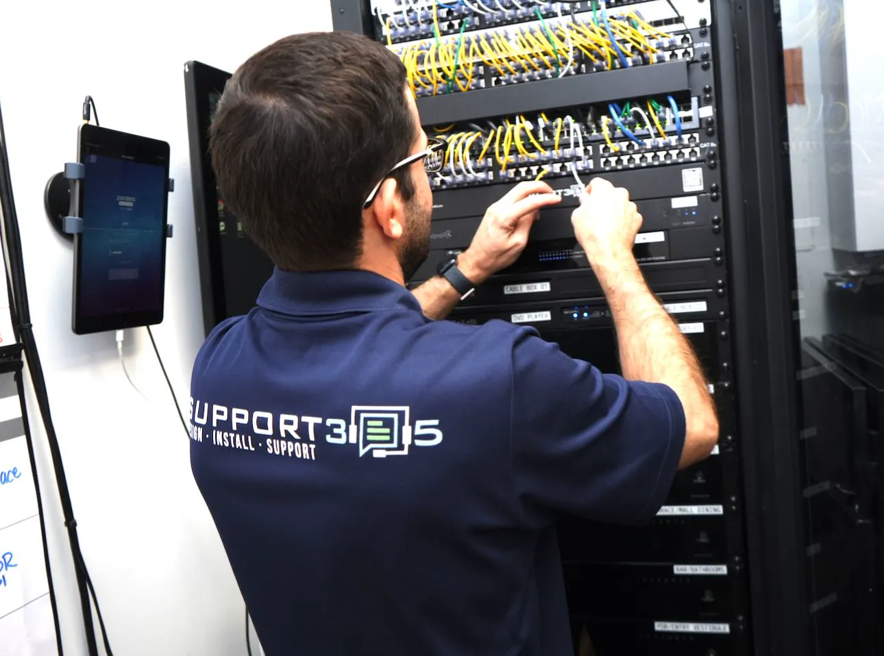 DIST technician patching cables in an equipment rack
